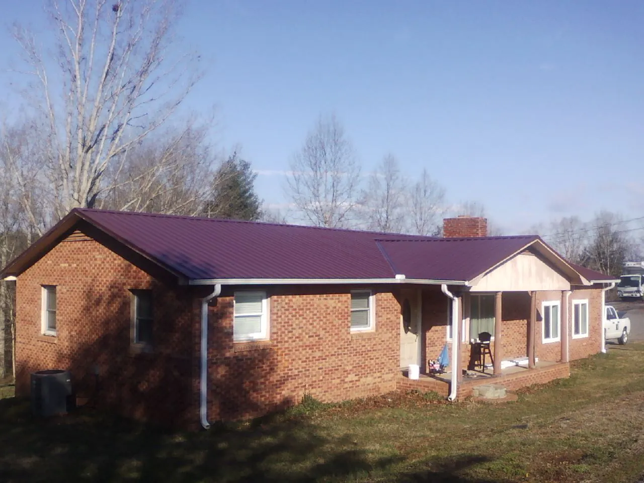 Burgundy metal roof on a brick ranch home with a new addition in Blair