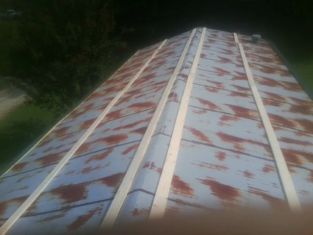 Rusted metal roof panels with new wood purlins before replacement — Storm Damage Roof Repair in Blair by Roofing Brothers