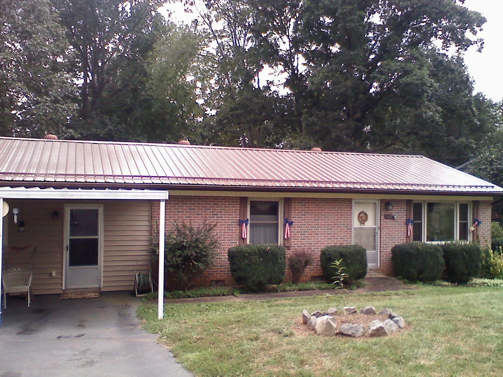Bronze metal roof and carport on a brick ranch home — Roof Repair work by our crew in Blair
